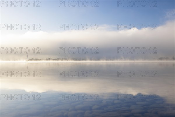 Fog over Lake Constance on an autumn morning with boats