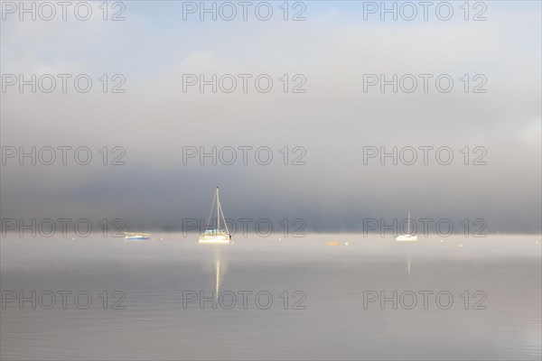 Fog over Lake Constance on an autumn morning with boats