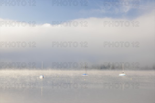 Fog over Lake Constance on an autumn morning with boats