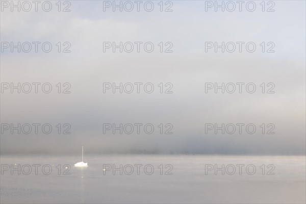 Fog over Lake Constance on an autumn morning with boats