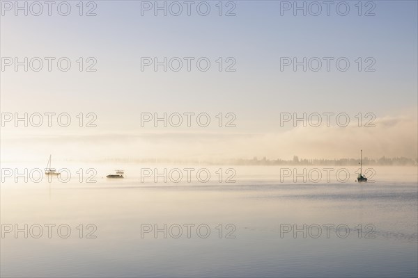 Fog over Lake Constance on an autumn morning with boats