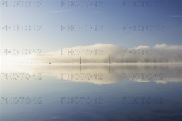 Fog over Lake Constance on an autumn morning with boats