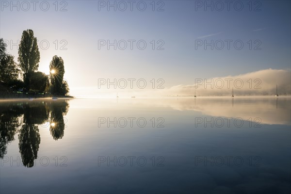 Fog over Lake Constance on an autumn morning with boats