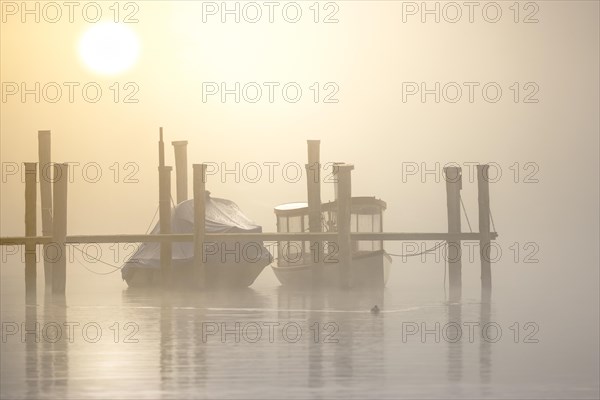 Fog over Lake Constance on an autumn morning with boats and old steamboat
