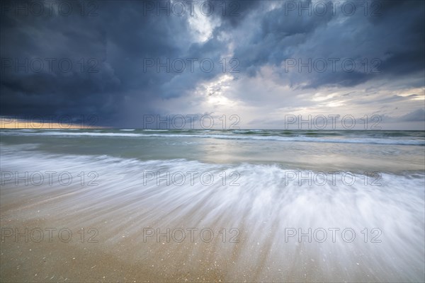 Evening mood with cloudy sky and rain on the beach and in the dunes of De Panne