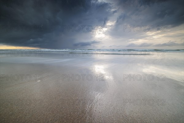 Evening mood with cloudy sky and rain on the beach and in the dunes of De Panne