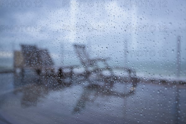 Raindrops on a window pane looking out onto the terrace