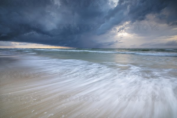 Evening mood with cloudy sky and rain on the beach and in the dunes of De Panne