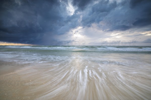 Evening mood with cloudy sky and rain on the beach and in the dunes of De Panne