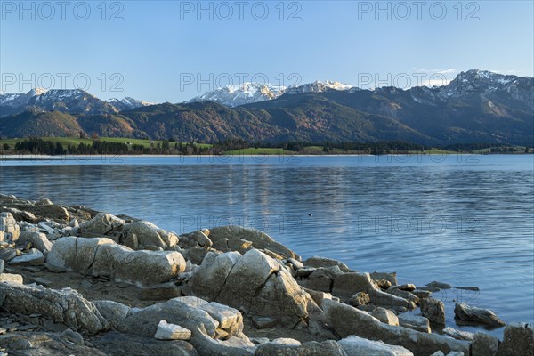 Lake Forggensee in the Allgäu in autumn. Rock formations in the foreground