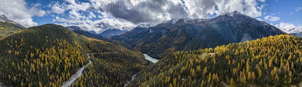 Colourful autumn landscape with a view of the Swiss National Park and the Lai dad Ova Spin reservoir