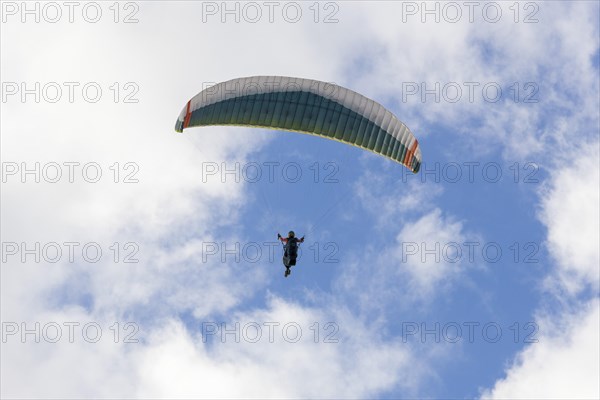Paraglider in the sky in front of clouds