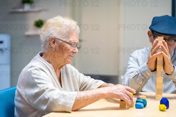 Old woman and man in a nursing home playing skill games
