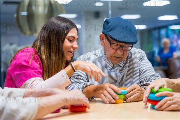 Nurse advising a elder man playing skill games in a nursing home