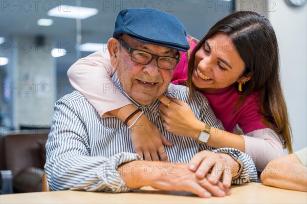 Tender moment of a nurse embracing a elder man in a geriatric