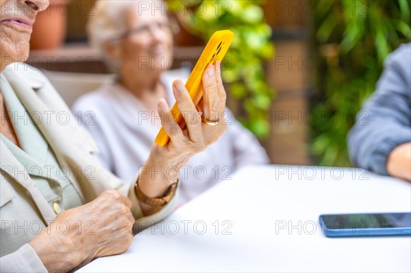 Close-up of elder woman using phone to listening to music in a geriatric