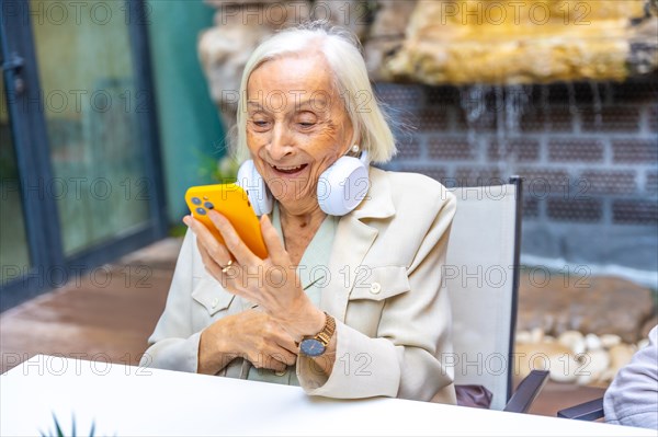 Amazed elder woman discovering technology to listening to music in a geriatric