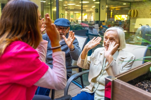 Nurse working on psychomotor skills with seniors sitting on a garden in a nursing home