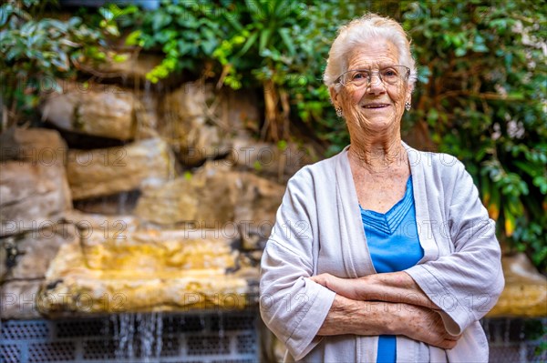 Smiling elder woman looking at camera and smiling in the garden of a nursing home