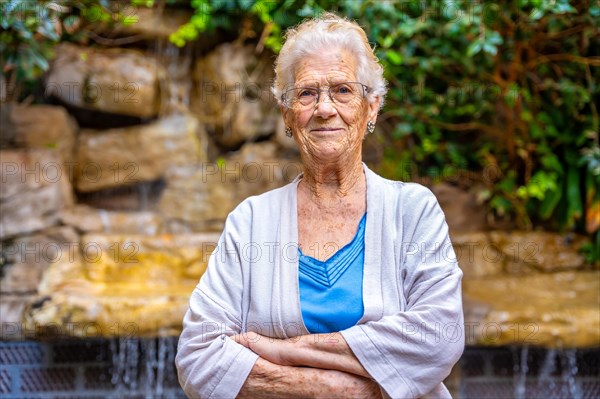 Proud elder woman looking at camera in the garden of a nursing home