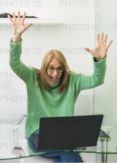 Portrait of excited mid-adult woman celebrating success