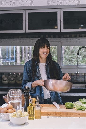 Smiling woman holding a wok