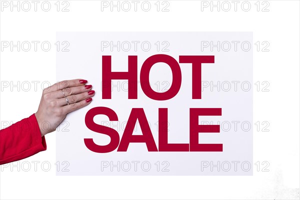 Woman hand holding a HOT SALE white poster on transparent background. Studio shot. Commercial concept