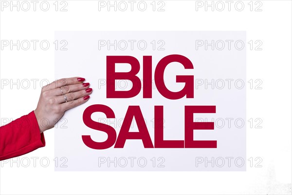 Woman hand holding a BIG SALE white poster on transparent background. Studio shot. Commercial concept