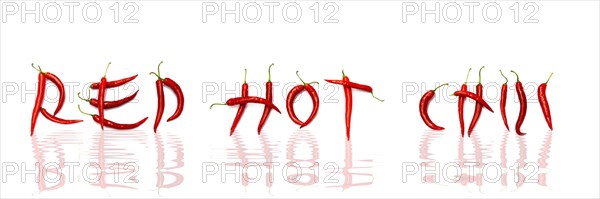 Red chilli peppers arranged to spell out RED HOT CHILI . The chillies are against a white background