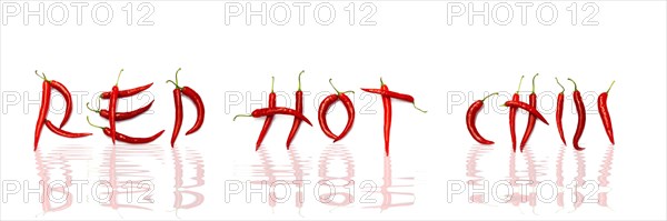 Red chilli peppers arranged to spell out RED HOT CHILI . The chillies are against a white background