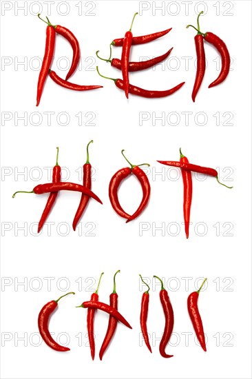 Red chilli peppers arranged to spell out RED HOT CHILI . The chillies are against a white background