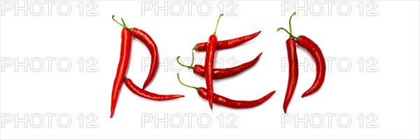 Red chilli peppers arranged to spell out RED HOT CHILI . The chillies are against a white background