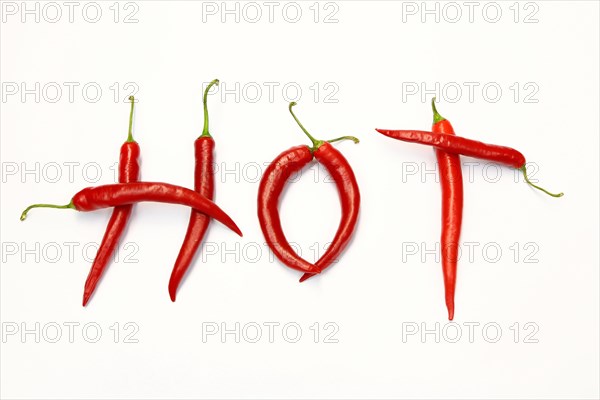 Red chilli peppers arranged to spell out RED HOT CHILI . The chillies are against a white background