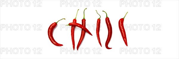 Red chilli peppers arranged to spell out RED HOT CHILI . The chillies are against a white background