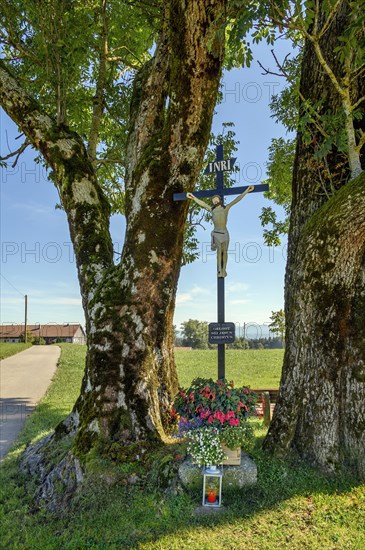Wayside cross with flower decoration and grave light