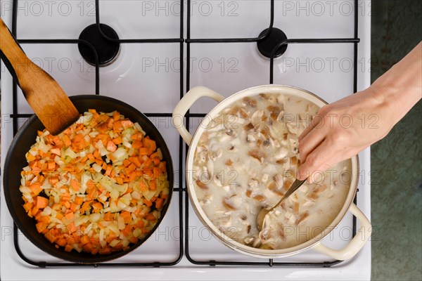 Top view of unrecognizable woman mixing soup in a casserole on a stove