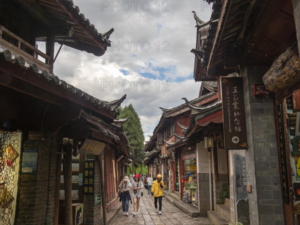 Alleys with old Chinese wooden houses and strolling passers-by