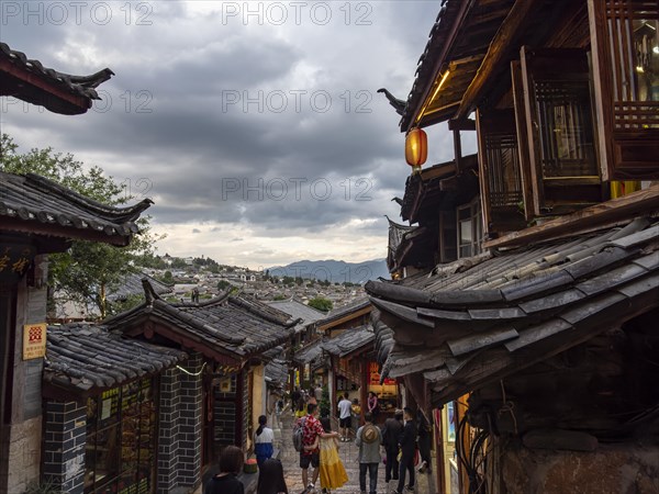 Alleys with old Chinese wooden houses and strolling passers-by