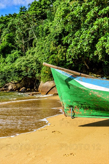 Rustic rowing canoe used for fishing on a paradisiacal beach and desert on Ilha Grande in Angra dos Reis