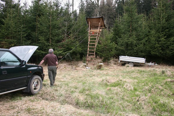 Setting up a hunter's stand at the edge of the forest with the help of a winch