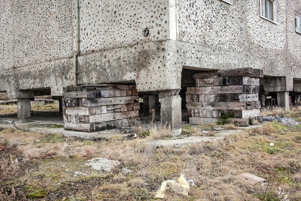 Pallets support a residential building that is in danger of sinking due to the thawing permafrost