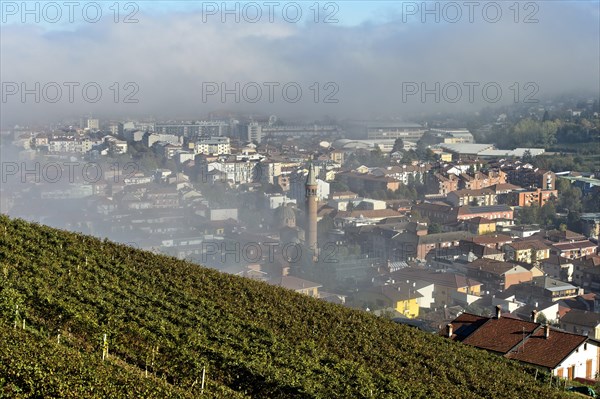 The town of Alba with the parish church of Madonna della Moretta in autumn mist