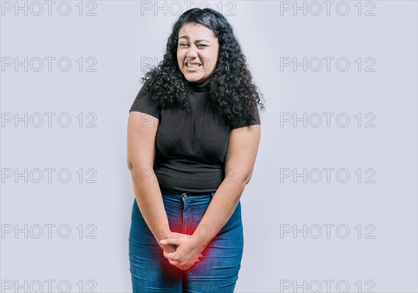 Girl with hands on crotch with urinary problems. People with urinary incontinence on white background. Young woman with urinary problems isolated