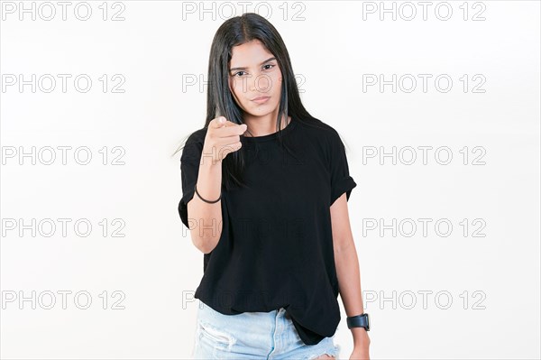 Young girl pointing at you frowning isolated. Serious girl pointing at the camera