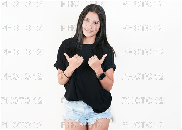 Smiling latin girl pointing both sides on isolated background. Cheerful girl recommending with fingers