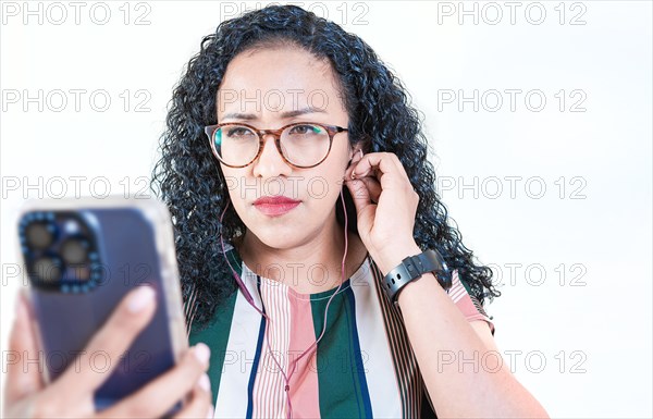 Young afro woman listening to music with headphones isolated. Close up of afro girl listening songs with celphone on isolated background