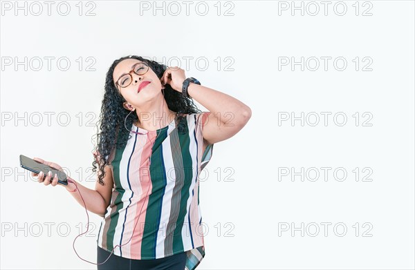 Relaxed afro girl enjoying music with phone isolated. Young afro woman listening to music with earphones isolated