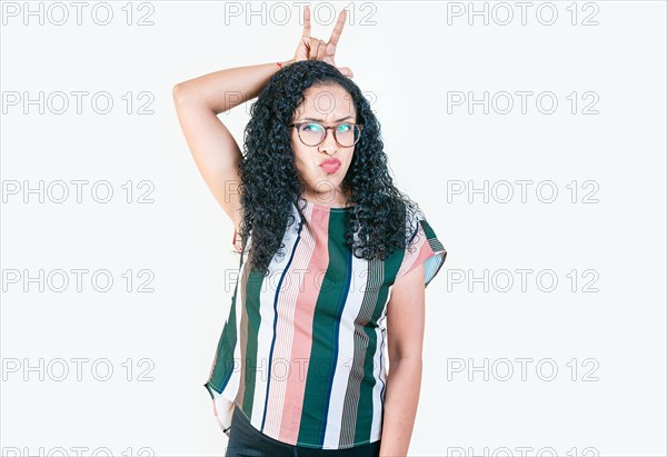 Young afro girl making horns gesture with fingers. Afro girl making horns gesture with their fingers