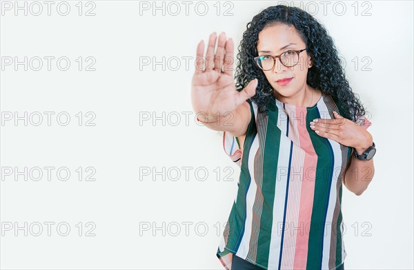 Young afro woman rejecting with the palm hand isolated. Afro girl gesturing stop isolated. Latin girl gesturing stop with palm hand isolated