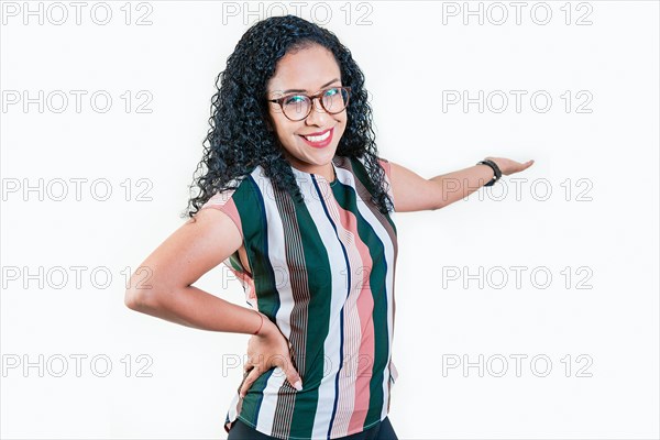 Happy afro girl pointing back presenting a product isolated. Cheerful people pointing a promotion with her palm. Smiling young afro woman welcoming you